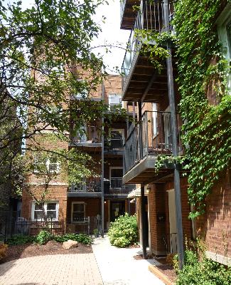 View of a multi-story brick apartment building with balconies.