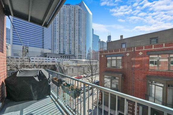 View from a balcony overlooking city buildings and a street.