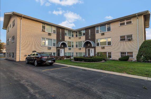 Front view of a two-story apartment building with brick exterior.