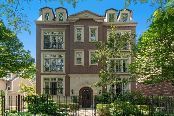 Front view of a four-story building with multiple windows and decorative balconies.