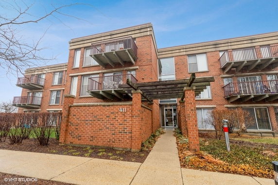 Front view of a three-story brick building with balconies.