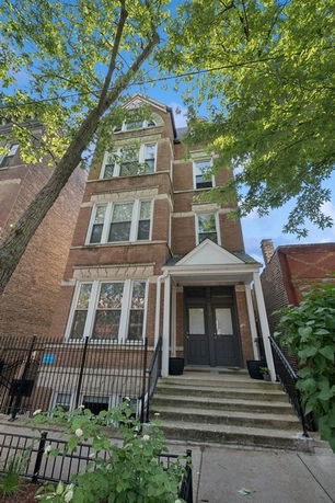 Front view of a multi-story brick building with a small entrance porch.