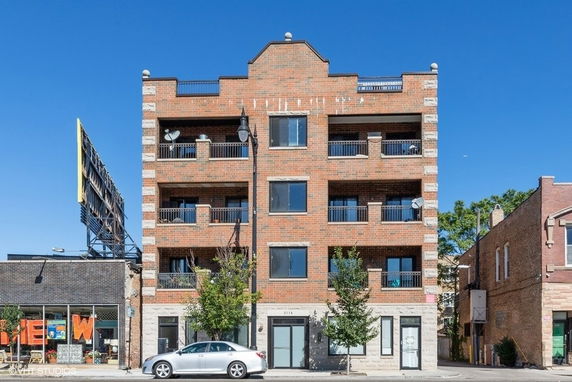 Front view of a multi-story brick building with balconies.