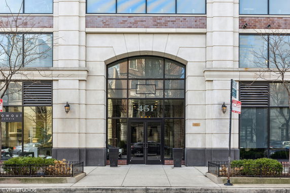 Front view of a building with large glass entrance and brick facade.