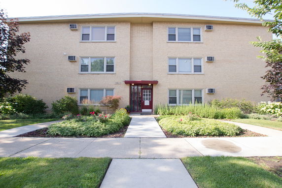 Front view of a multi-story apartment building with a central entrance.