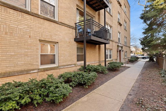 Front view of a multi-story brick building with a balcony.