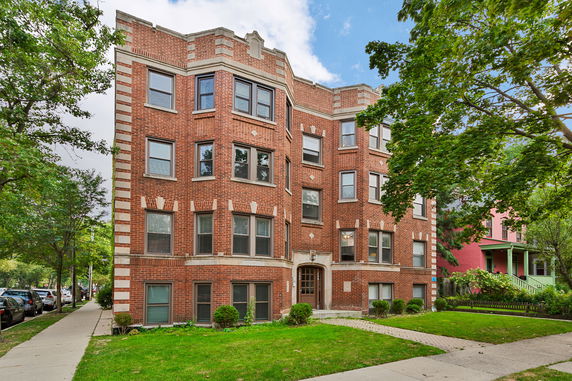 Front view of a multi-story brick building with multiple windows and a central entrance.