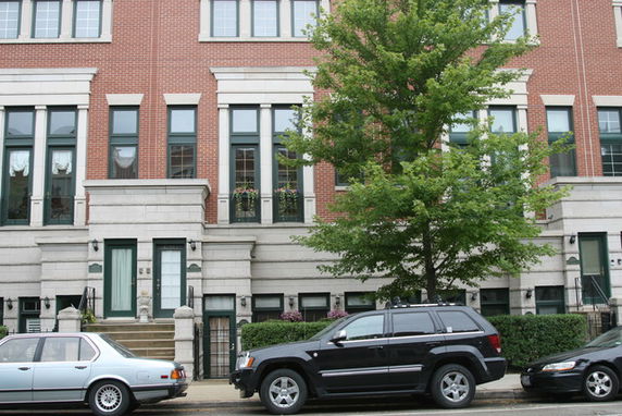 Front view of a multi-story brick building with large windows.