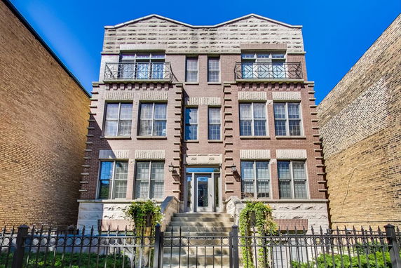 Front view of a multi-story brick building with multiple windows and a central entrance.