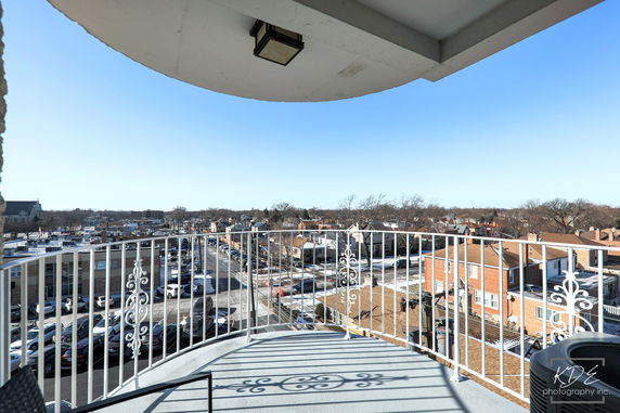 Panoramic view from a balcony overlooking rooftops and a street below.