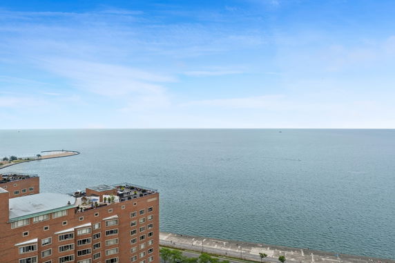Panoramic view of a large body of water with a brick building in the foreground.
