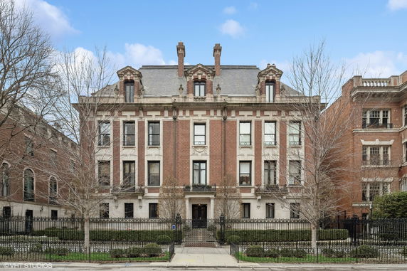 Front view of a multi-story brick building with tall windows.