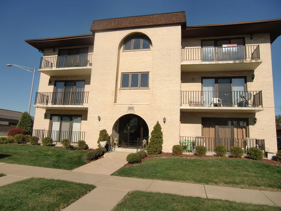 Front view of a three-story apartment building with balconies.