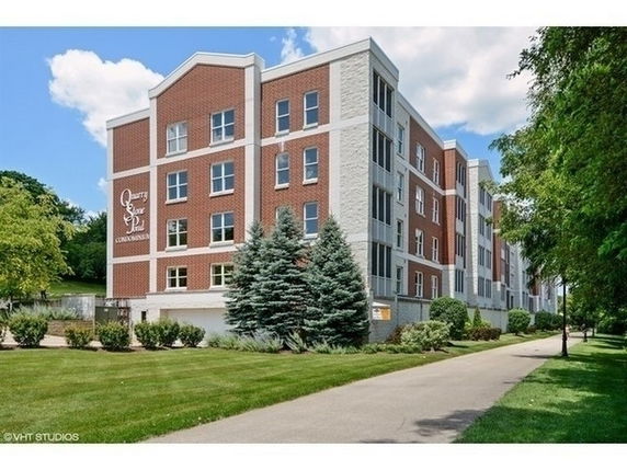 Front view of a multi-story condominium building with brick facade.