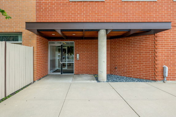 Front view of a brick building entrance with a glass door.