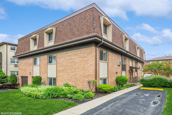 Front view of a two-story residential building with brick and siding exterior.
