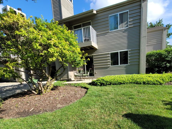 Front view of a two-story house with a balcony and chimney.