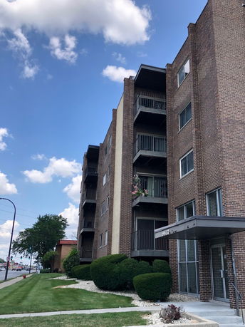 Front view of a multi-story brick apartment building.