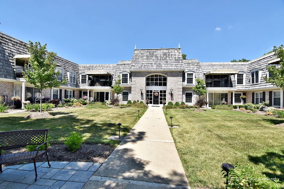 Front view of a two-story building with a central entrance and surrounding landscaping.