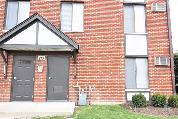 Front view of a brick building with two doors and windows.