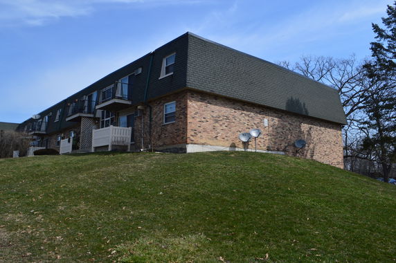 Front view of a two-story brick apartment building with balconies.