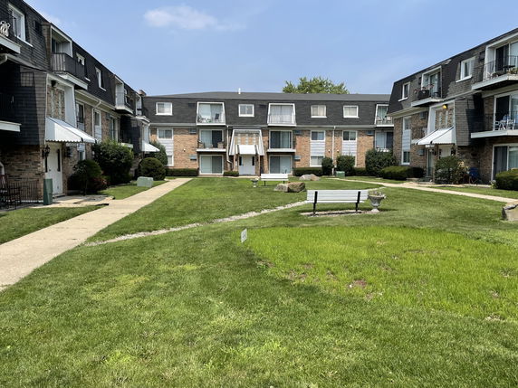 Front view of a multi-story apartment building with balconies.