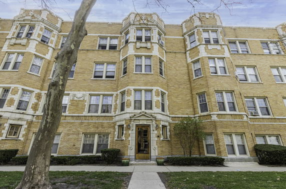 Front view of a multi-story brick apartment building.