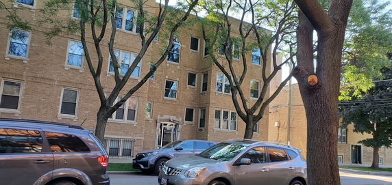 Front view of a multi-story apartment building with brick exterior.