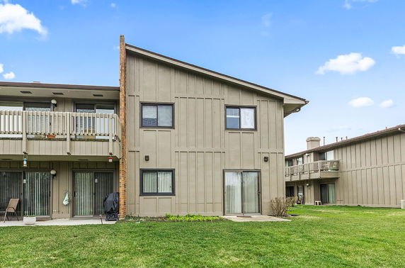 Front view of a split-level apartment building with balconies and sliding glass doors.