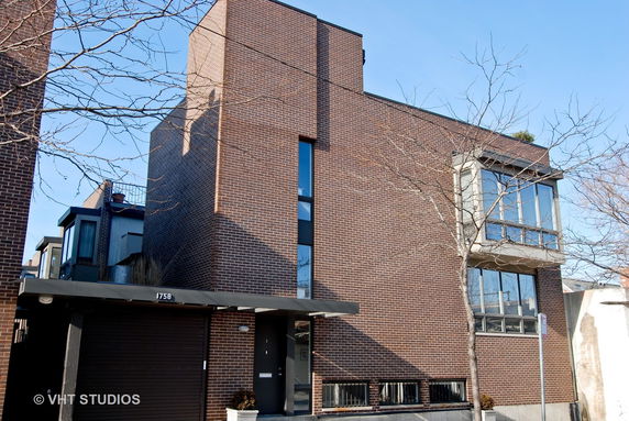 Front view of a multi-story brick building with large windows.