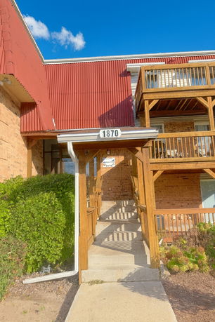 Front view of a building with a red roof and wooden balconies.