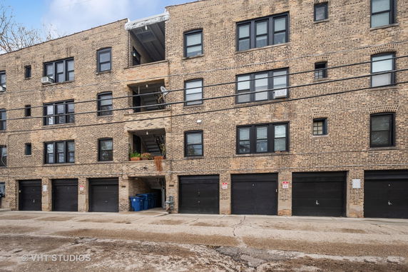 Front view of a multi-story brick building with multiple garage doors.