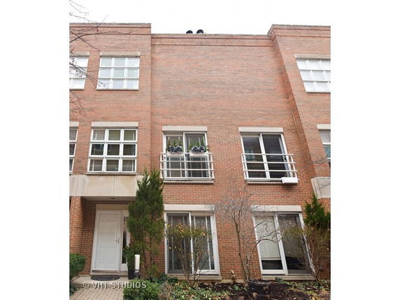 Front view of a multi-story brick building with multiple windows and small balconies.