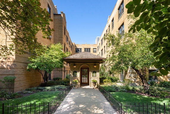 Front view of a brick apartment building with a central entrance.