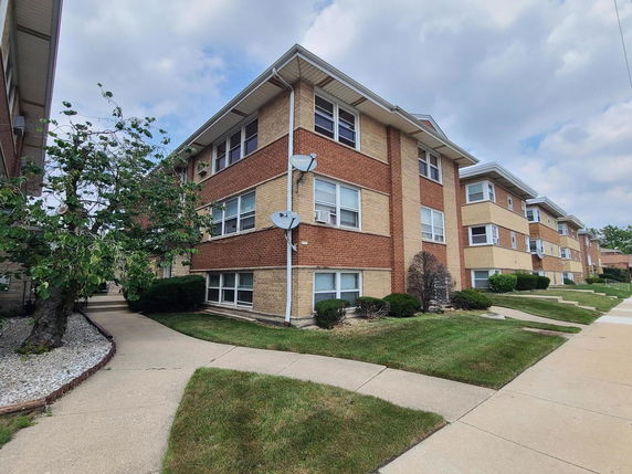 Front view of a multi-story brick apartment building.