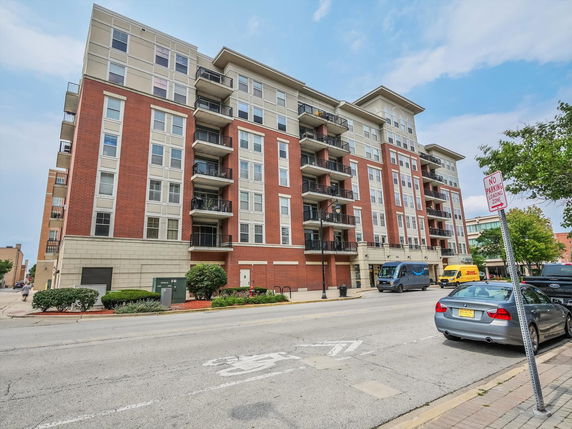 Front view of a multi-story apartment building with red brick and beige exterior.
