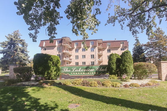 Front view of a multi-story condominium building with balconies and a sign reading 'The Lakeview Club Condominiums'.