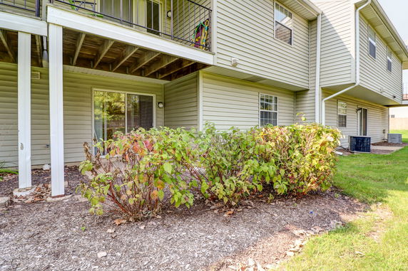 Rear view of a two-story house with a sliding glass door and balcony.