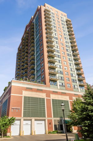 Front view of a tall residential building with multiple balconies.