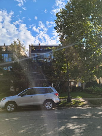 Front view of a multi-story residential building with a glass facade.
