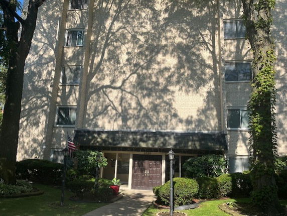 Front view of a multi-story residential building with visible windows and entrance.