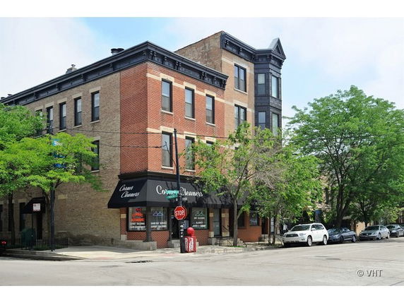 Front view of a multi-story commercial building with a corner store.