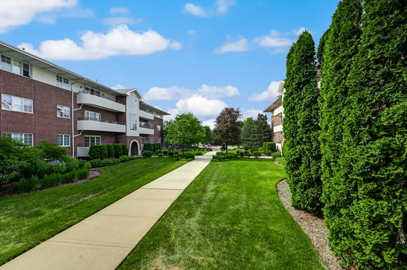 Front view of a multi-story brick apartment building with balconies.