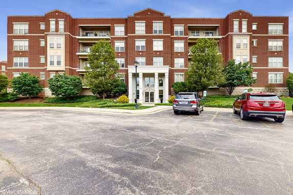 Front view of a multi-story brick apartment building with a central entrance.