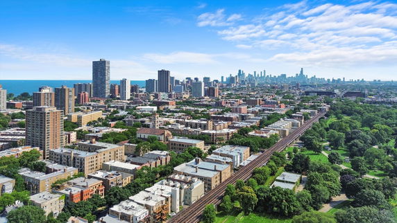 Wide angle view of a cityscape with multiple high-rise buildings and green areas.