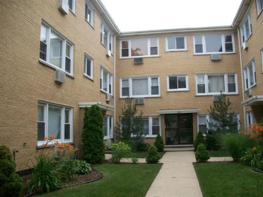 Front view of a three-story apartment building with a courtyard.