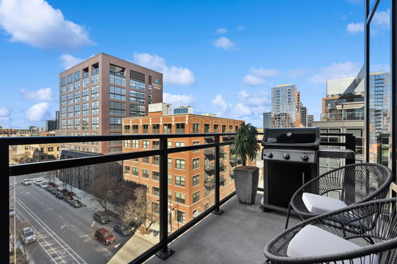 Panoramic view from a balcony overlooking city buildings.
