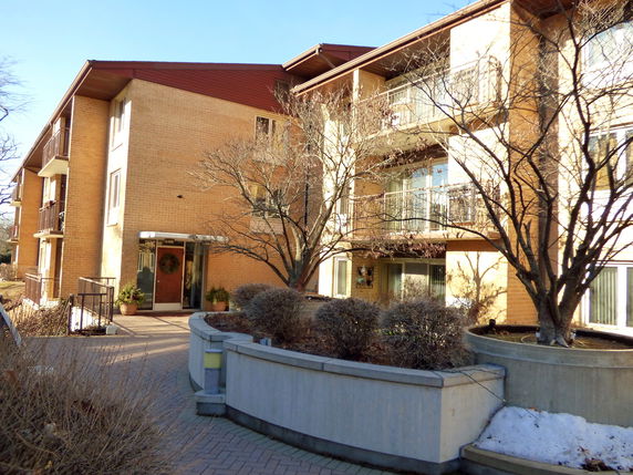 Front view of a multi-story apartment building with balconies.