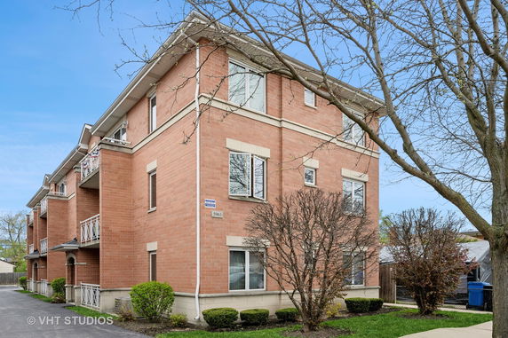 Front view of a three-story brick building with balconies.