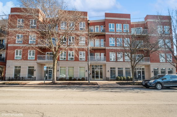 Front view of a multi-story brick building with balconies.